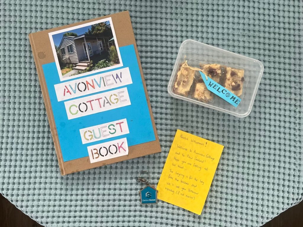 Eine Begrüßung aus Gästebuch, handschriftlicher Notiz und selbstgebackenem Kuchen